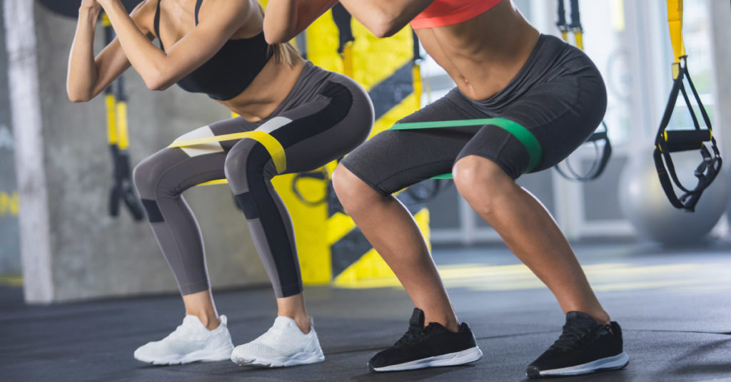 Imagen mujer haciendo sentadilla con liga 