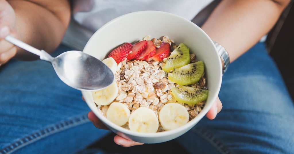 Imagen mujer comiendo avena con frutas 